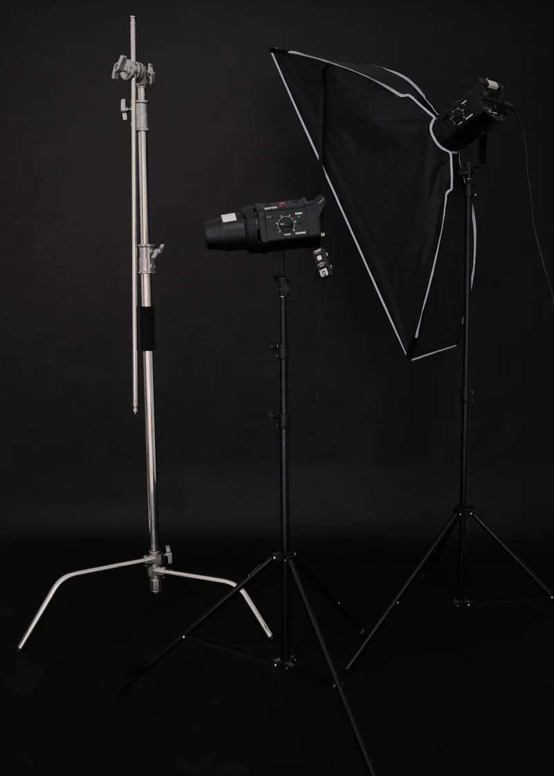 Softbox lights on stands against a black backdrop, ready for a production shoot
